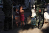 Honduran migrant girls play near Mexican National Guards where Central American migrants camp out on the Mexican shore of the Suchiate River on the border with Guatemala, near Ciudad Hidalgo, Mexico, at sunrise Tuesday, Jan. 21, 2020. Hundreds of Central American migrants are stranded in a sort of no-man's land on the river border between Guatemala and Mexico after running up against lines of Mexican National Guard troops deployed to keep them from moving en masse on Monday into the country and on north toward the U.S. (AP Photo/Marco Ugarte)