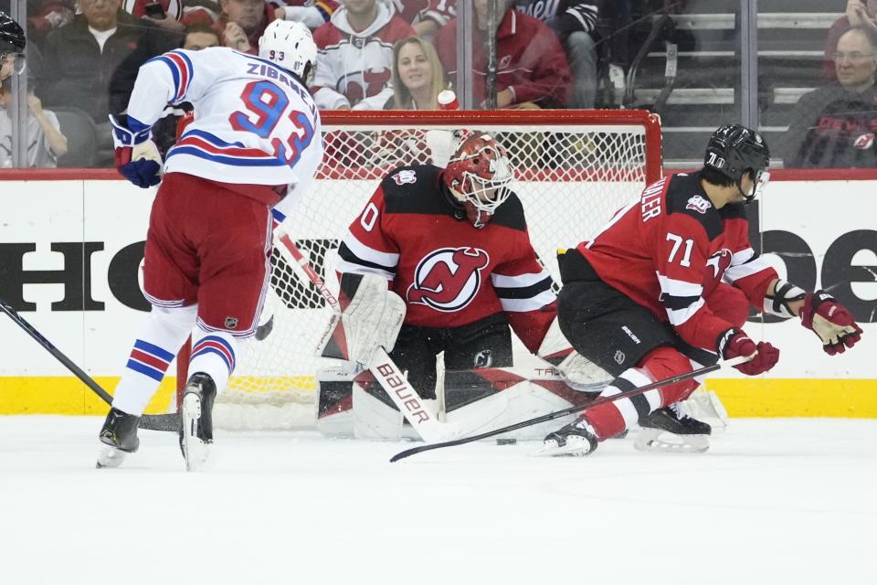 New Jersey Devils goaltender Akira Schmid (40) stops a shot by New York Rangers' Mika Zibanejad (93) during the second period of Game 5 of an NHL hockey Stanley Cup first-round playoff series Thursday, April 27, 2023, in Newark, N.J. (AP Photo/Frank Franklin II)