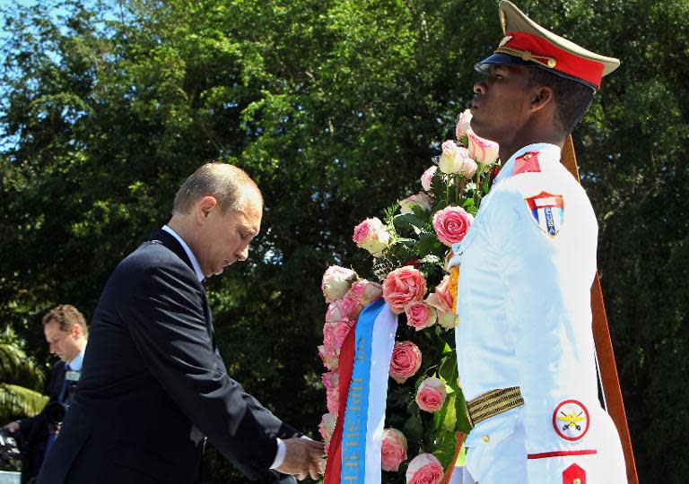 Russian President Vladimir Putin (L) attends a wreath-laying ceremony at the Soviet Soldier Monument in Havana on July 11, 2014