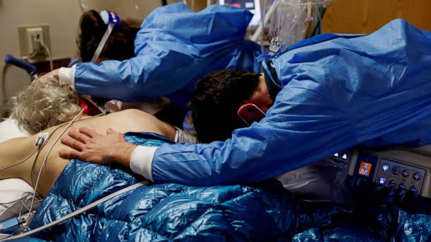 PHOTO: FILE PHOTO: A son and daughter embrace their father, a coronavirus disease (COVID-19) patient in the Intensive Care Unit (ICU) ward, before his intubation procedure at the Providence Mission Hospital in Mission Viejo, California, Jan. 25, 2022.  (Shannon Stapleton/Reuters)