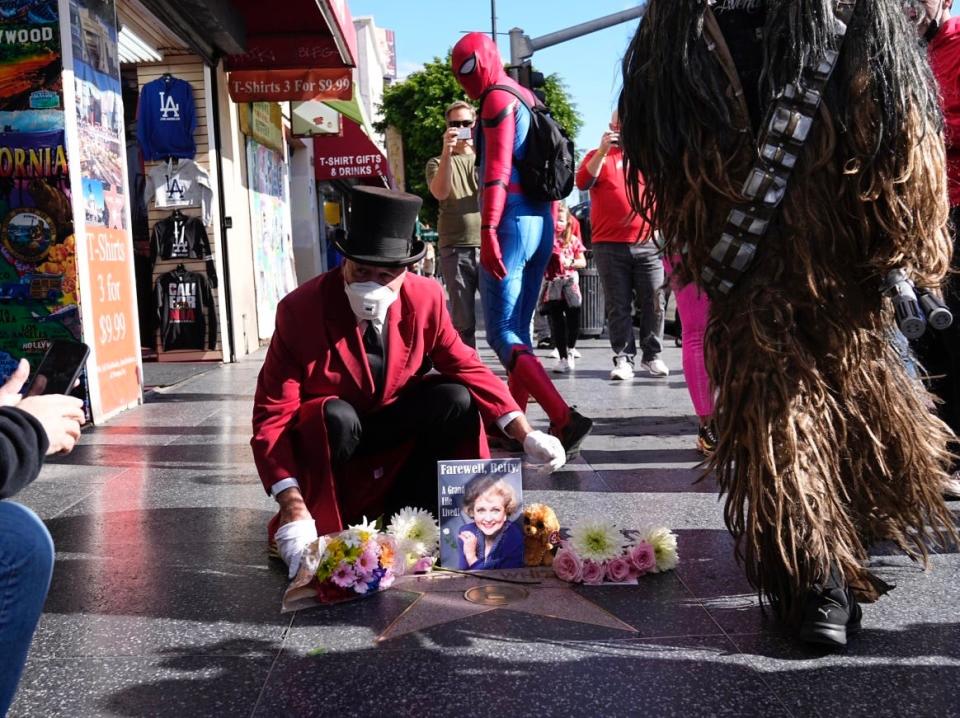 Gregg Donovan, 62, of Santa Monica places a tribute on Betty White’s star on the Hollywood Walk of Fame following the actress’ death.