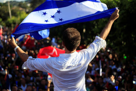 Salvador Nasralla, presidential candidate for the Opposition Alliance Against the Dictatorship, holds the Honduran flag as he speaks to his supporters during a protest while the country is still mired in chaos over a contested presidential election in Tegucigalpa, Honduras December 3, 2017. REUTERS/ Jorge Cabrera