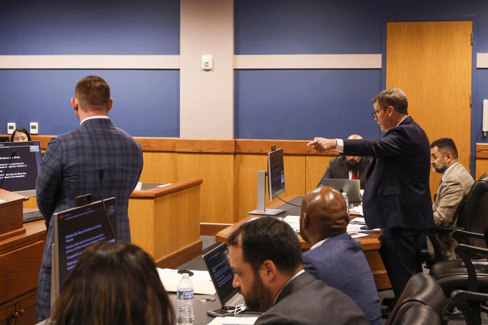 Brian Rafferty, right, attorney for Sidney Powell, addresses Fulton County Superior Court Judge Scott McAfee while gesturing towards Deputy District Attorney Will Wooten, left, during a hearing on motions in Atlanta, Thursday, Oct. 5, 2023. Nineteen people, including former President Donald Trump, were indicted in August and accused of participating in a wide-ranging illegal scheme to overturn the results of the 2020 presidential election. (Erik S. Lesser/Pool Photo, via AP)