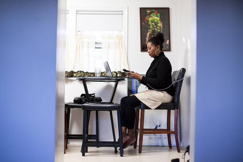 Mona Pompilus works in her kitchen in Foxborough. After a long day of visiting clients for her employer, she often records her notes at home. (Photo: Kayana Szymczak for Yahoo News)