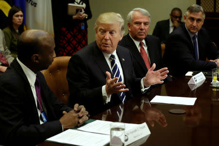 U.S. President Donald Trump talks with Kenneth Frazier (L) CEO of Merck as Robert Hugin (2nd R) Executive Chairman of Celgene and Robert Bradway (R) CEO of Amgen look on during a meeting with Pharma industry representatives at the White House in Washington, U.S., January 31, 2017. REUTERS/Yuri Gripas