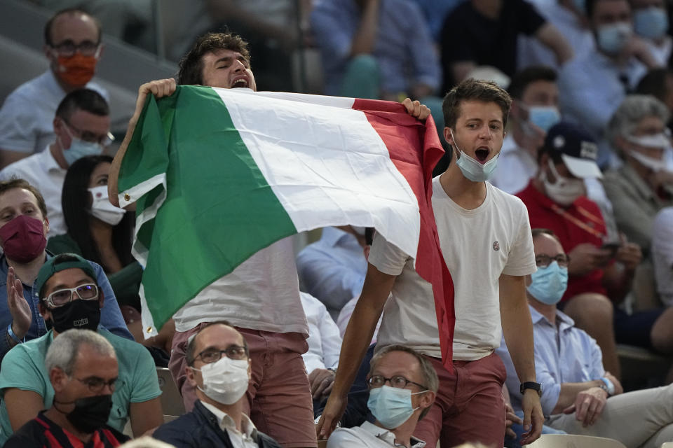 Italian tennis lovers support Italy's Matteo Berrettini playing Serbia's Novak Djokovic during their quarterfinal match of the French Open tennis tournament at the Roland Garros stadium Wednesday, June 9, 2021 in Paris. (AP Photo/Michel Euler)