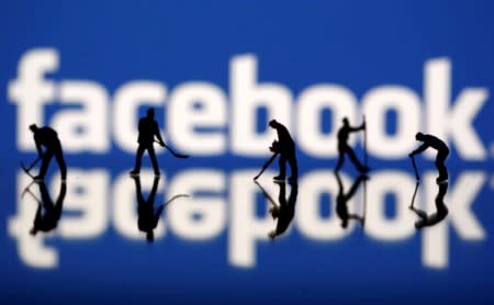 FILE PHOTO: Figurines are seen in front of the Facebook logo in this illustration taken March 20, 2018. REUTERS/Dado Ruvic