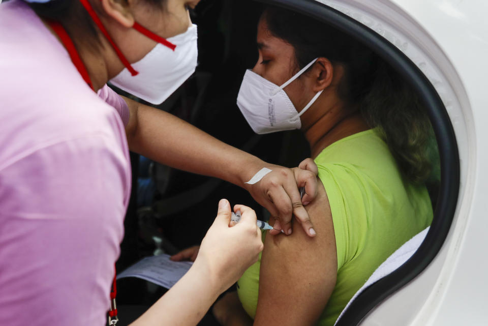 FILE - In this June 9, 2021, file photo, a health worker administers Covishield, Serum Institute of India's version of the AstraZeneca vaccine, during a drive-in vaccination program in Kolkata, India. Starting June 21, 2021, every Indian adult can get a COVID-19 vaccine dose for free that was purchased by the federal government. The policy reversal announced last week ends a complex system of buying vaccines that worsened inequities in accessing vaccines. India is a key global supplier of vaccines and its missteps have left millions of people waiting unprotected. The policy change is likely to address inequality but questions remain and shortages will continue. (AP Photo/Bikas Das, File)