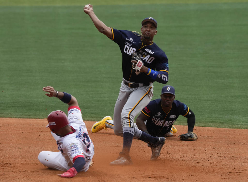 Jonathan Schoop de Curazao lanza la bola a primera base tras etiquetar al panameño Iván Herrera en la Serie del Caribe el sábado 4 de febrero del 2023. (AP Foto/Fernando Llano)