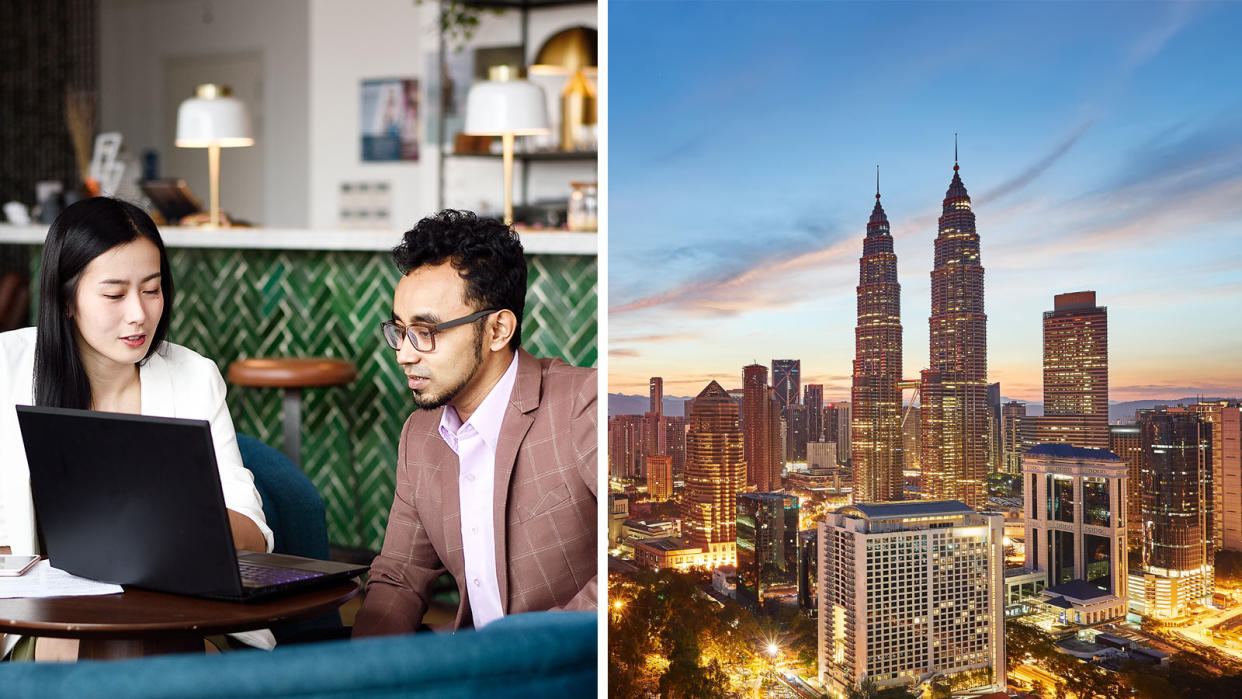 Woman blouse in white talking to man in brown suit, Kuala Lumpur skyline