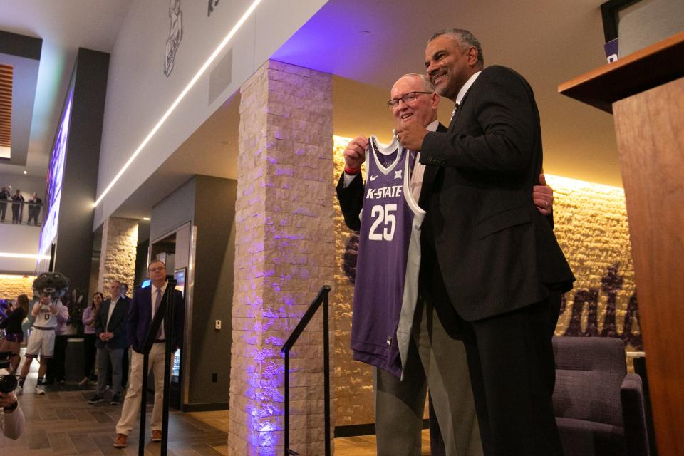 Jerome Tang, Kansas State’s new men’s basketball coach, proudly holds up a jersey with athletic director Gene Taylor inside Bramlage Coliseum Thursday for his introduction press conference. Tang was assistant coach at Baylor for 19 seasons before being selected as K-State’s head coach Monday.