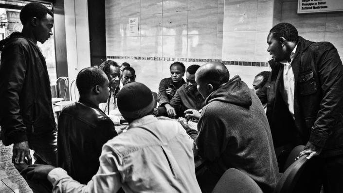 A group of men play domino&#39;s in an African caf&#xe9; in Newport