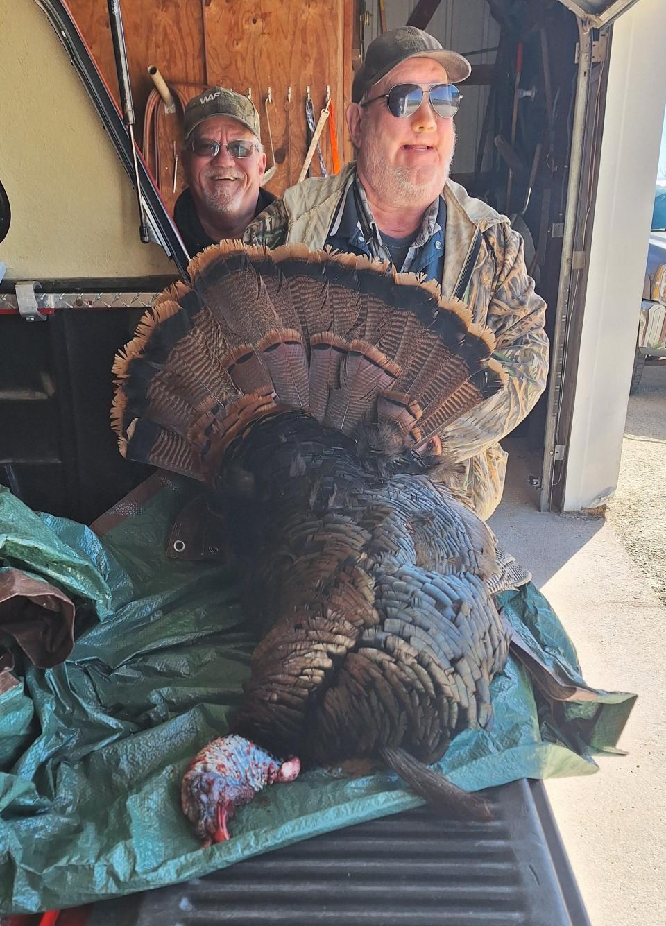 Rick Schuh (left) looks on as Bob Schuh shows the tom turkey he shot on April 24. The tom weighed in at 23 pounds, sported an 8-inch beard with 7/8-inch spurs. He was hunting in the Kellnersville area.