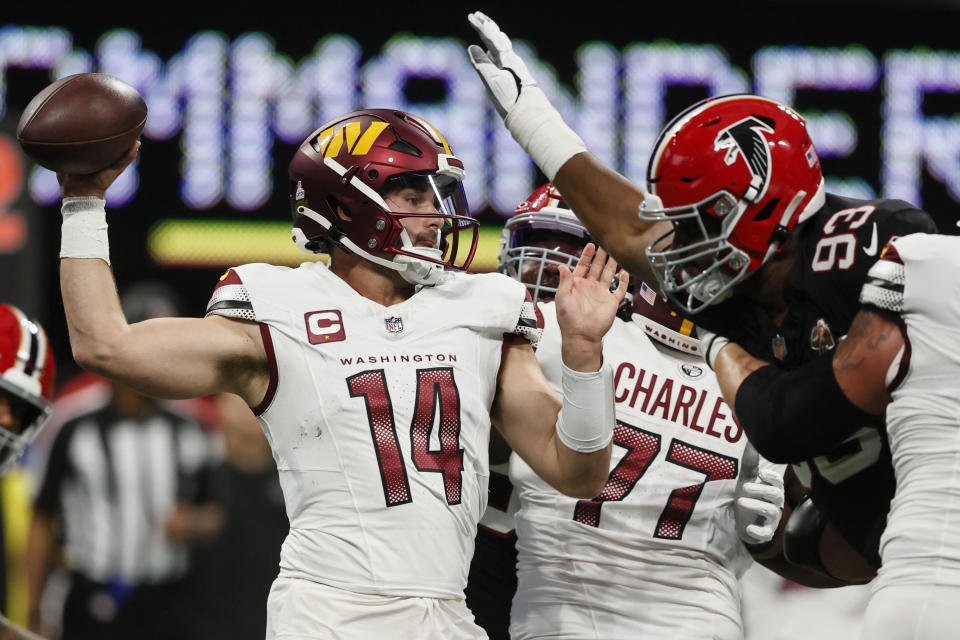 Washington Commanders quarterback Sam Howell (14) works under pressure by Atlanta Falcons defensive tackle Calais Campbell (93) during the first half of an NFL football game, Sunday, Oct. 15, 2023, in Atlanta. (AP Photo/Butch Dill)