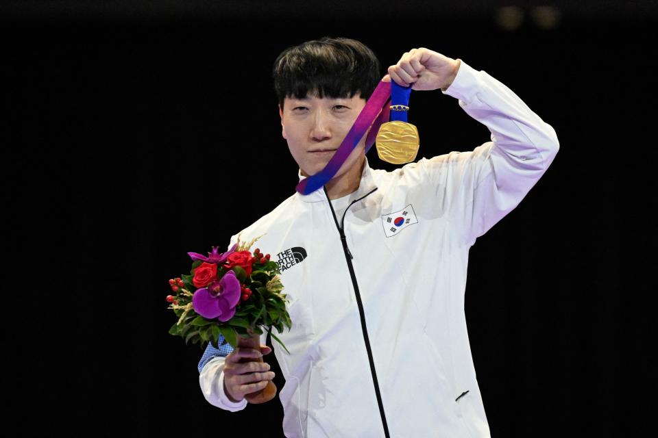South Korea's Kim Gwanwoo (L) poses with his gold medal during an award ceremony after winning the "Street Fighter V: Champion Edition" final esports event during the 2022 Asian Games in Hangzhou in China's eastern Zhejiang province on September 28, 2023. 