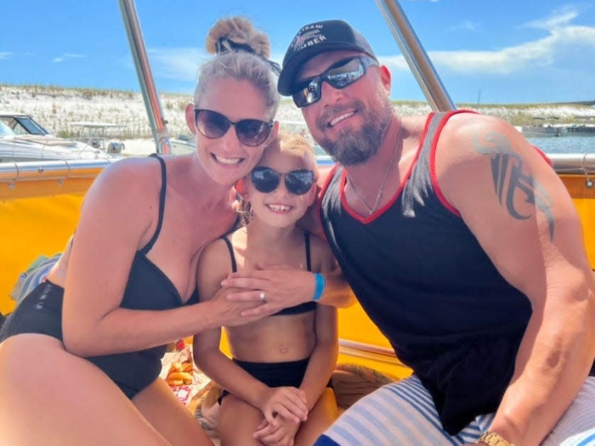 Jamie Hilburn on a beach with fiance and his daughter