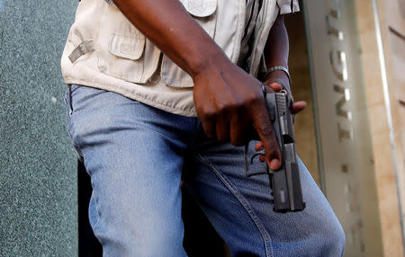 FILE PHOTO: A member of security forces holds a pistol at the scene where explosions and gunshots were heard at the Dusit hotel compound, in Nairobi, Kenya January 15, 2019. REUTERS/Thomas Mukoya/File Photo