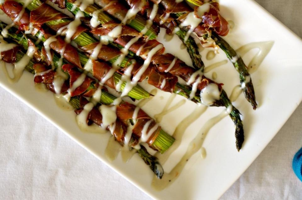 <p>Shea Goldstein</p><p>This springtime veggie gets a major flavor boost with prosciutto and a cheese sauce.</p><p><strong>Get the recipe: <a href="https://parade.com/886654/sheagoldstein/prosciutto-wrapped-asparagus-with-gruyere-sauce/" rel="nofollow noopener" target="_blank" data-ylk="slk:Prosciutto-Wrapped Asparagus with Gruyere Sauce;elm:context_link;itc:0;sec:content-canvas" class="link ">Prosciutto-Wrapped Asparagus with Gruyere Sauce</a></strong></p>