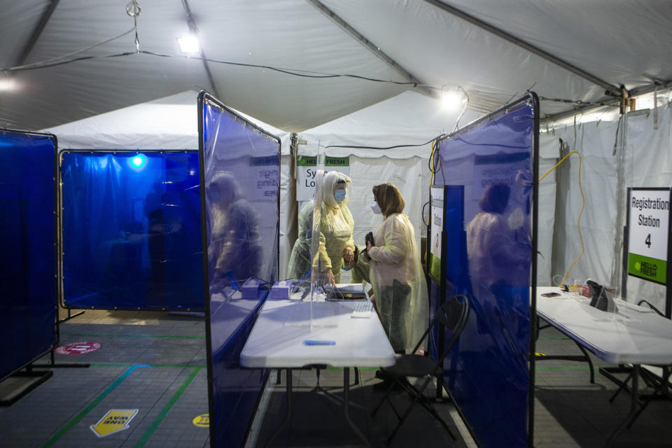 Healthcare workers prepare for the opening of a Hello Fresh vaccination site for its employees, in Mississauga, Ontario, Tuesday Dec. 28, 2021. (Chris Young/The Canadian Press via AP)