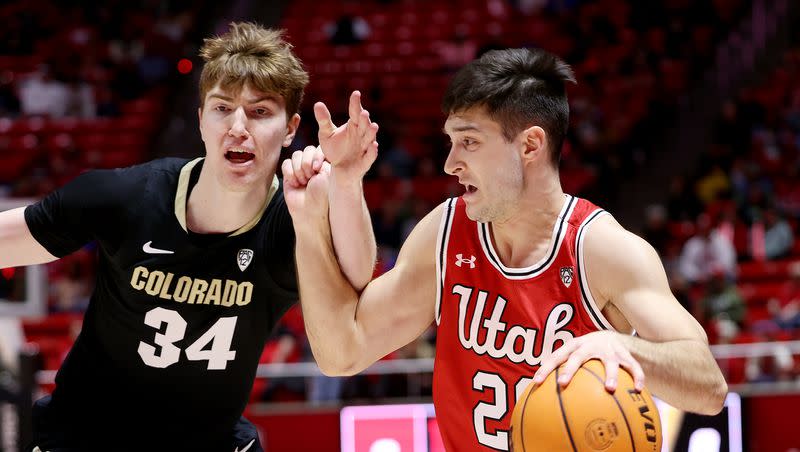 Utah Utes guard Lazar Stefanovic (20) works to get away from Colorado Buffaloes center Lawson Lovering (34) as Utah and Colorado play in the Huntsman Center at the University of Utah in Salt Lake City on Saturday, Feb. 11, 2023. Lovering announced his transfer to Utah.