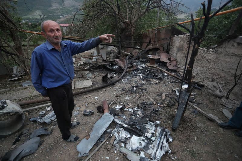 A man stands in a household, which locals said was damaged during a recent shelling by Azeri forces, in Hadrut