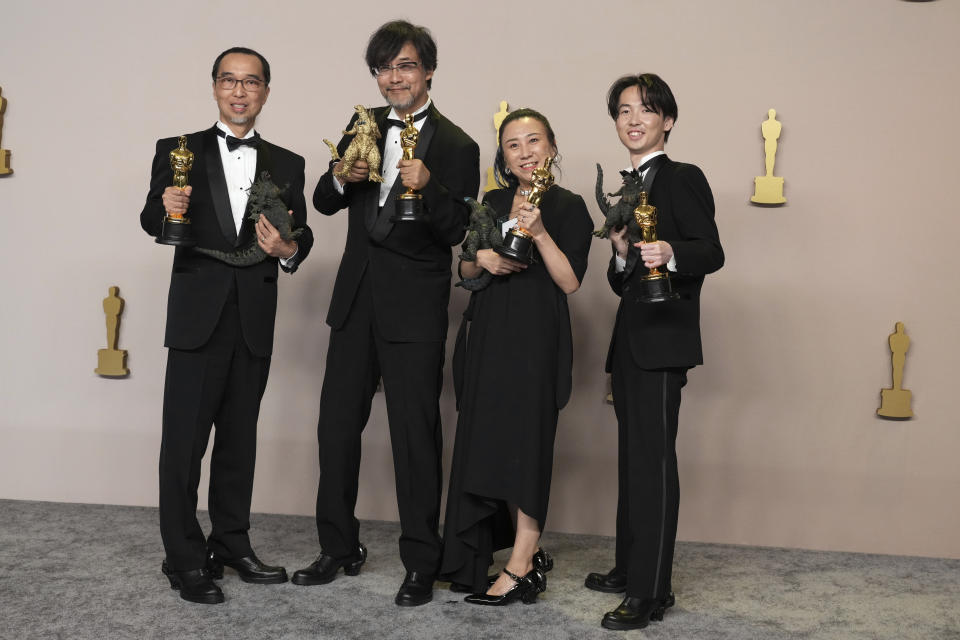 ARCHIVO - Masaki Takahashi, de izquierda a derecha, Takashi Yamazaki, Kiyoko Shibuya, y Tatsuji Nojima posan en la sala de prensa con el premio a mejores efectis visuales por "Godzilla Minus One" en los Oscar el 10 de marzo de 2024, en el Teatro Dolby en Los Ángeles. Una creación japonesa que llamó la atención en la alfombra roja de los Oscar no era una película, sino los zapatos que parecían atrapados en la garra de Godzilla, obra de Ryosuke Matsui. (Foto Jordan Strauss/Invision/AP, archivo)