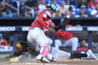 Pittsburgh Pirates' Oneil Cruz slides into home safely as Miami Marlins catcher Christian Bethancourt is unable to hang onto the throw during the fifth inning of a baseball game, Saturday, March 30, 2024, in Miami. (AP Photo/Wilfredo Lee)
