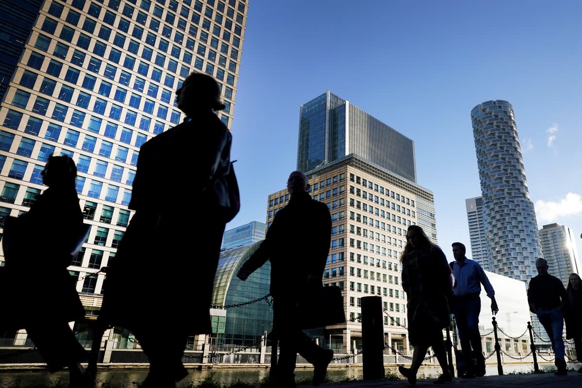 Office workers and commuters walk through Canary Wharf in London during the morning rush (Victoria Jones/PA) (PA Archive)