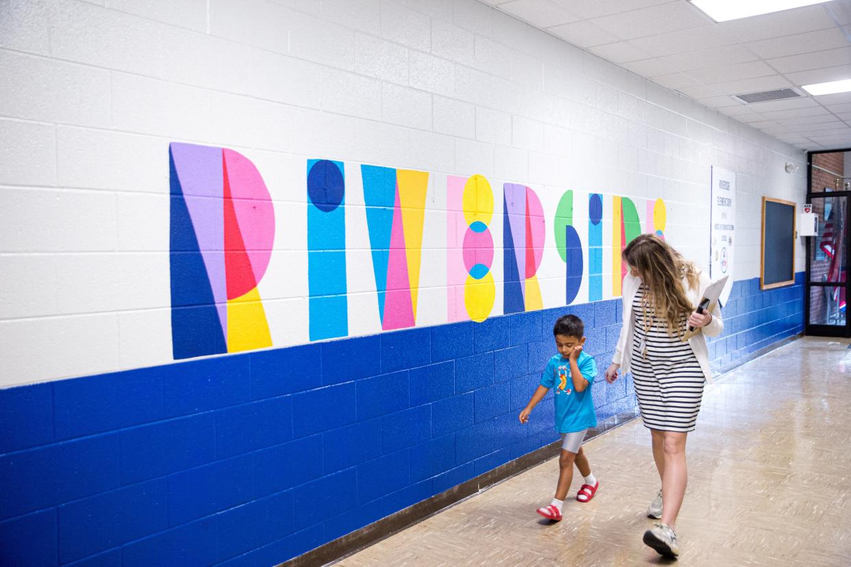 A teacher and a student walk dow a hallway together during the first day back at Riverside Elementary School in Columbia, Tenn. on Monday, Aug. 7, 2023.