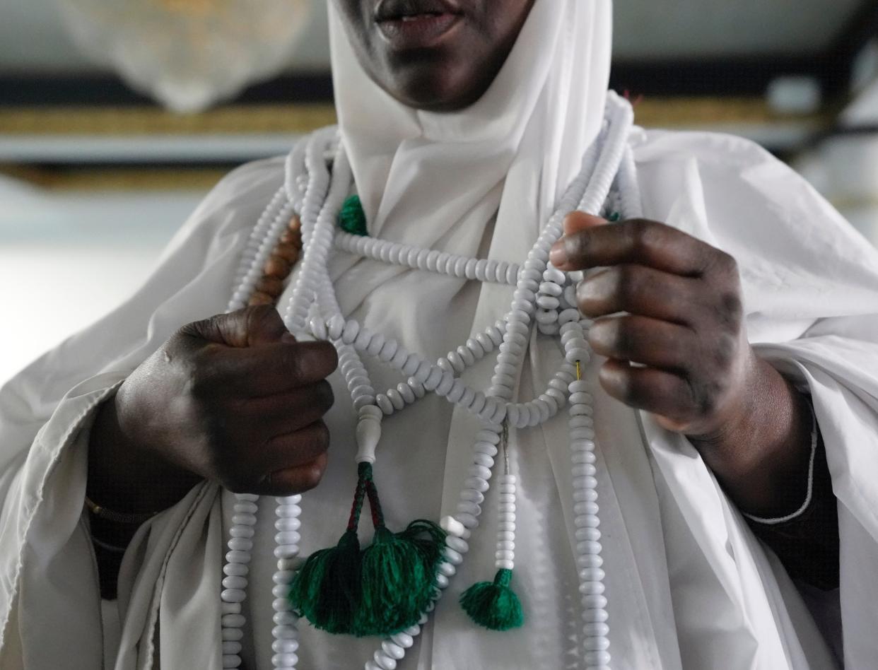 A woman wears a long strand of beads that assist her in keeping track of her prayer recitations on Dec. 8 at Abubakar Assidiq Islamic Center on Columbus' West Side.