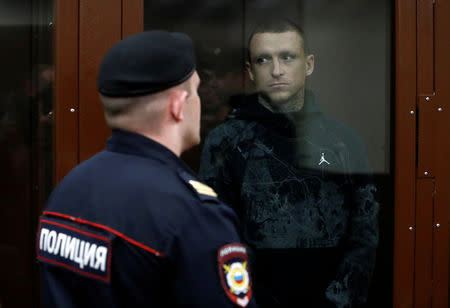 FILE PHOTO: Russian soccer player Pavel Mamayev, who was detained and accused of carrying out attacks, stands inside a defendants' cage during a court hearing in Moscow, Russia October 11, 2018. REUTERS/Sergei Karpukhin/File Photo