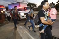 Decenas de migrantes que buscan llegar a Estados Unidos caminan por una carretera mientras salen de San Pedro Sula, Honduras, al amanecer del martes 15 de enero de 2019. (AP Foto/Delmer Martínez)