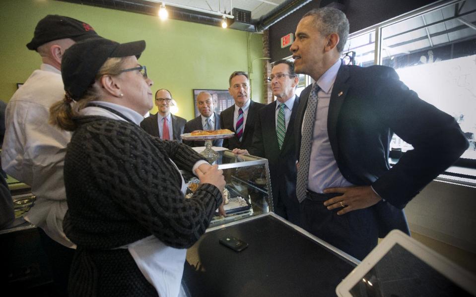 President Barack Obama greets owners Rob Chiovoloni, far left, and his wife Alice Bruno, during his unannounced visit to Café Beauregard in New Britain, Conn., Wednesday, March 5, 2014. Also at the counter, from left are, Labor Secretary Thomas Perez, Massachusetts Gov. Deval Patrick, Vermont Gov. Peter Shumlin and Connecticut Gov. Dannel P. Malloy. Obama traveled to Hartford, Conn., area to highlight the importance of raising the minimum wage and then will travel to Boston for a pair of Democratic fundraising. (AP Photo/Pablo Martinez Monsivais)