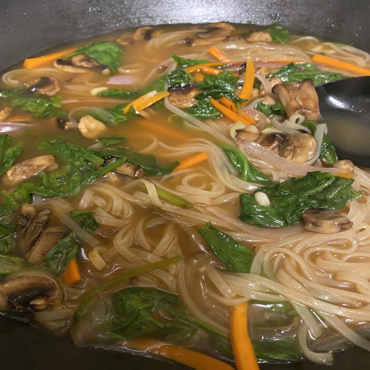 Broth, vegetables and noodles in a pot. 