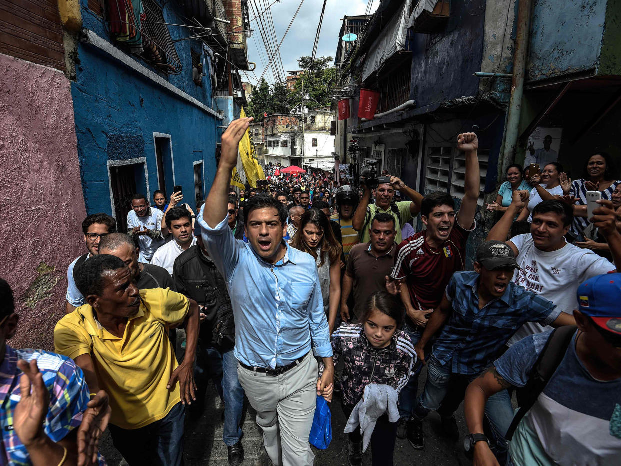 The opposition's candidate for governor for the state of Miranda, Mayor of Caracas' Sucre Municipality Carlos Ocariz (C) greets supporters: AFP/Getty Images