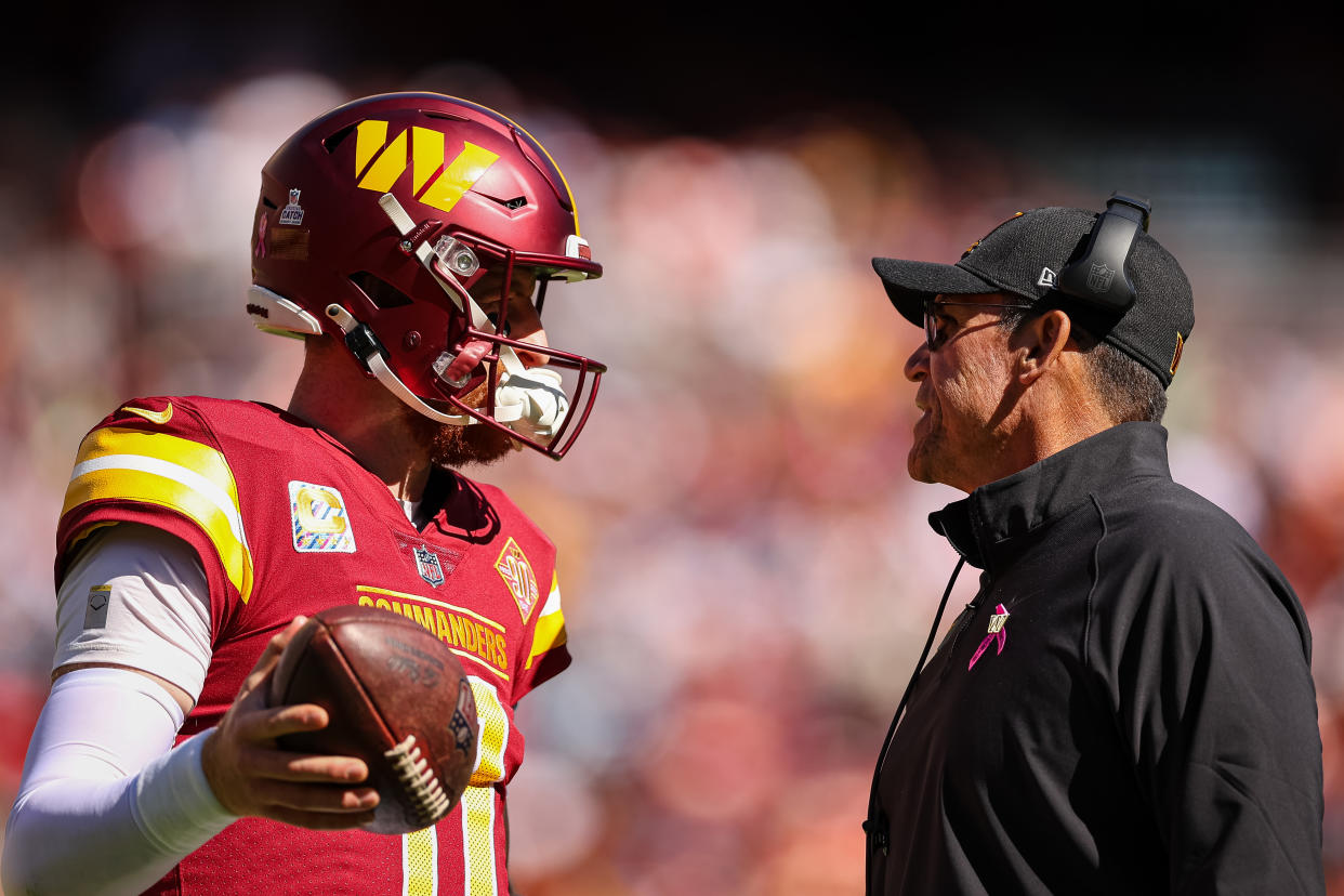 LANDOVER, MD - OCTOBER 09: Head coach Ron Rivera of the Washington Commanders speaks with quarterback Carson Wentz #11 during the first half of the game against the Tennessee Titans at FedExField on October 9, 2022 in Landover, Maryland. (Photo by Scott Taetsch/Getty Images)