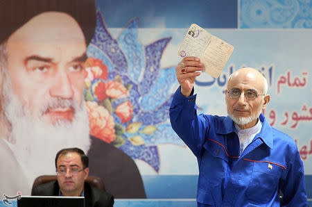 Mostafa Mirsalim, Iranian former minister of culture, holds his document as he registers his candidacy for presidential elections at the Interior Ministry in central Tehran, Iran, April 11, 2017. Tasnim News Agency/Handout via REUTERS