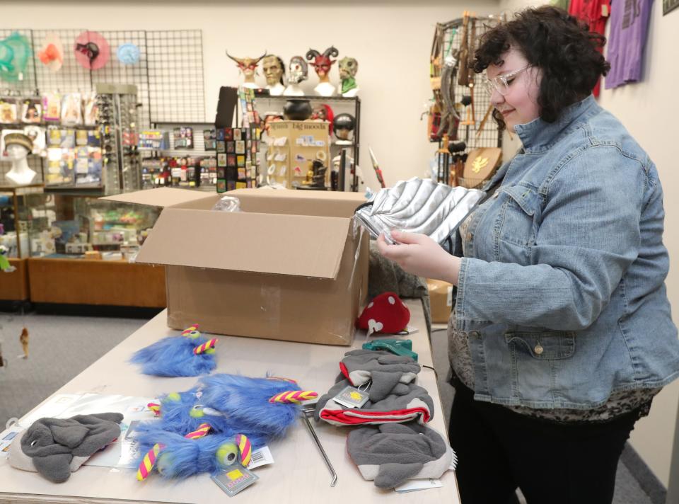 Mr. Fun's employee Paige Vogus unpacks dog costumes Tuesday at the new Front Street location in Cuyahoga Falls.