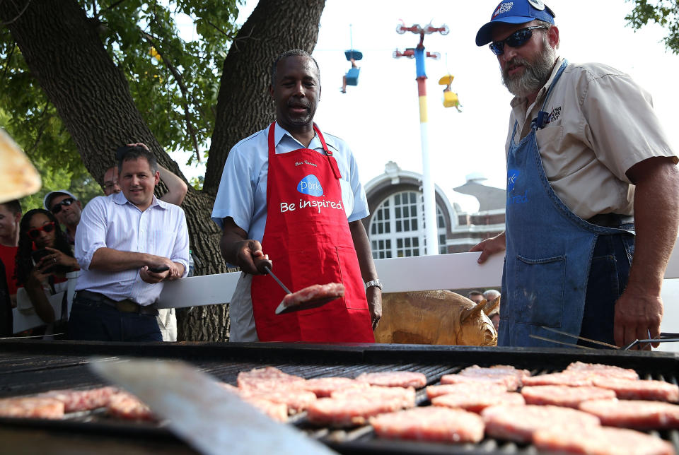 Republican presidential candidate Ben Carson flips pork burgers.