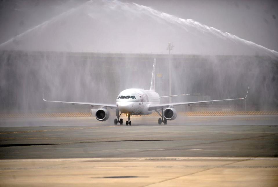 A traditional water salute welcomes Qatar Airways' inaugural flight to the new Hamad International Airport (HIA) in Doha, Qatar, on Wednesday, April 30, 2014. A massive new airport in the Qatari capital has started handling its first commercial flights after years of delays as the natural-gas rich Gulf nation works to transform itself into a major aviation hub. (AP Photo/Osama Faisal)