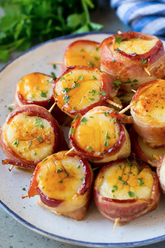 <p>Dinner at the Zoo</p><p>These bacon-wrapped scallops are jumbo scallops coated in a sweet and savory glaze, then broiled to perfection. A simple yet elegant appetizer or main course option that is sure to get rave reviews!</p><p><strong>Get the recipe: <a href="https://www.dinneratthezoo.com/bacon-wrapped-scallops/" rel="nofollow noopener" target="_blank" data-ylk="slk:Bacon-Wrapped Scallops;elm:context_link;itc:0;sec:content-canvas" class="link ">Bacon-Wrapped Scallops</a></strong></p>