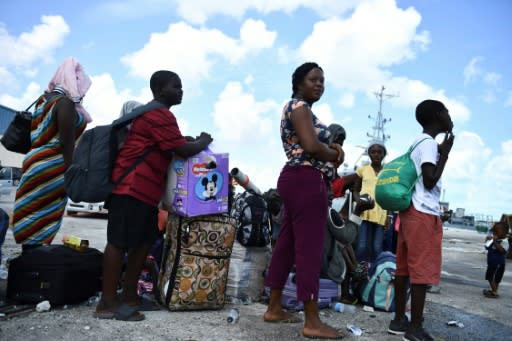 People await evacuation at a dock in Marsh Harbour in the Bahamas on September 7, 2019, in the aftermath of Hurricane Dorian