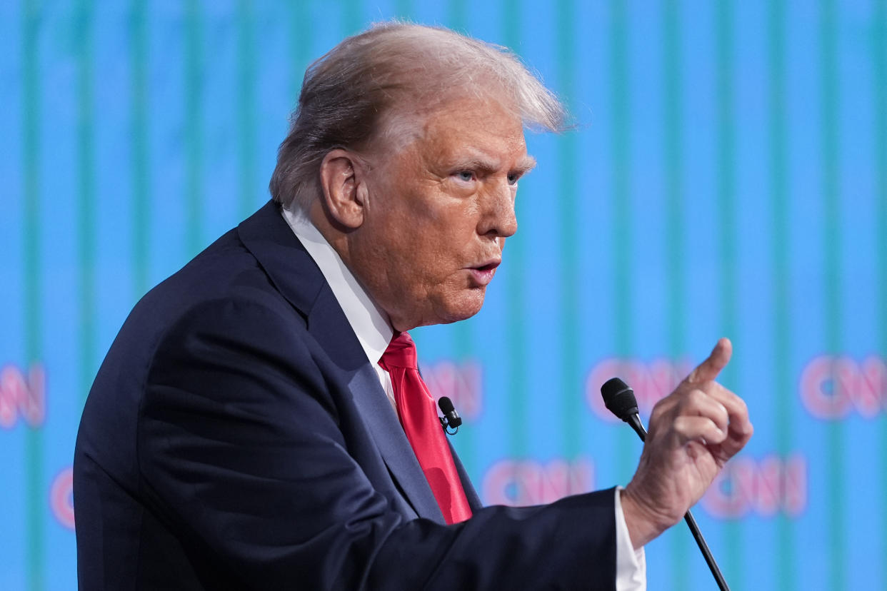 Trump gestures as he speaks at the podium.