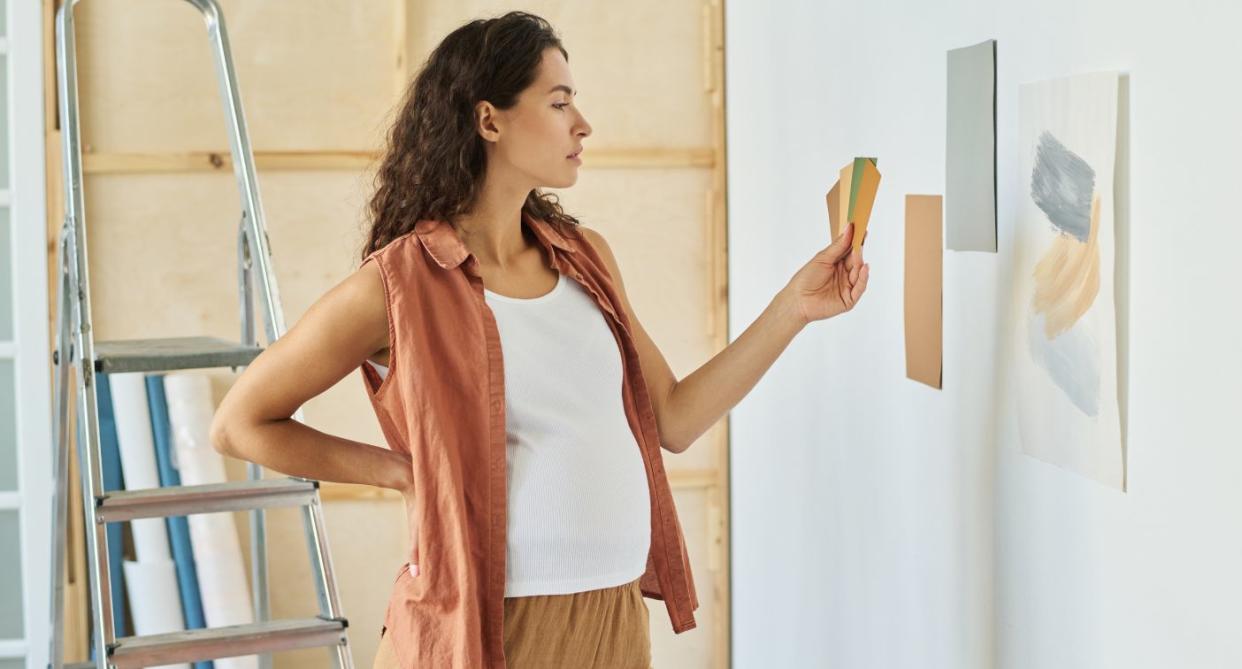 Pregnant woman decorating baby's room on maternity leave. (Getty Images)
