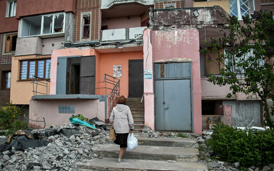 A local woman returns to her building, which was damaged in a shelling in Kharkiv - SERGEY KOZLOV/EPA-EFE/Shutterstock