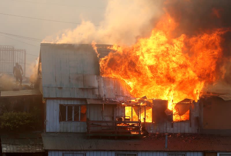 A house burns following the spread of wildfires in Valparaiso