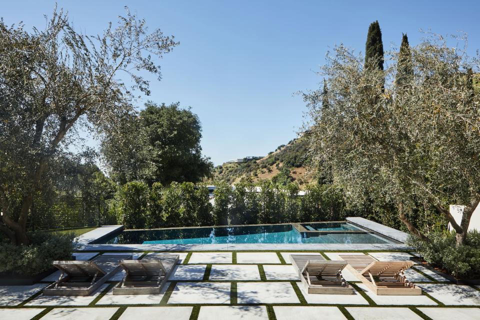 Furnished with outdoor teak chaise longues from Sutherland, the terrace provides peaceful views of the swimming pool and natural surroundings.