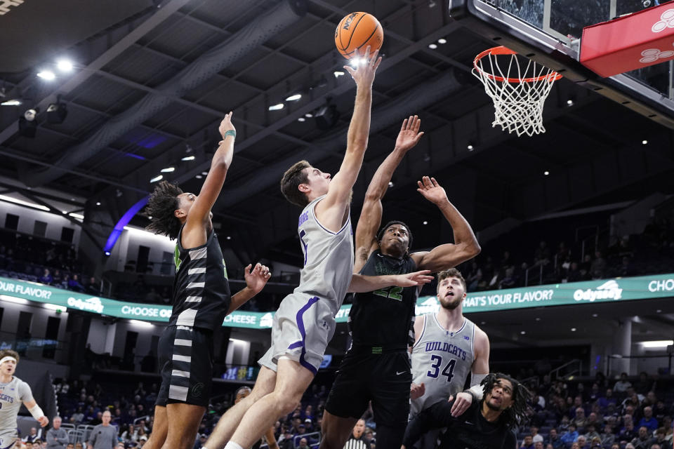 Northwestern guard Ryan Langborg, center, drives to the basket against Chicago State guard Jahsean Corbett, left, and forward Cameron Jernigan during the first half of an NCAA college basketball game in Evanston, Ill., Wednesday, Dec. 13, 2023. (AP Photo/Nam Y. Huh)