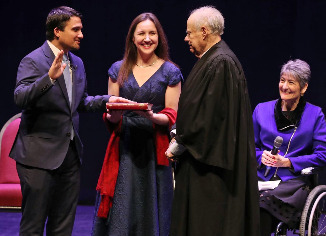 Akron Mayor Shammas Malik takes the oath of office, administered by retired Judge Ted Schneiderman, second from right, as Alice Duey holds the Quran and Malik's aunt, Mary Theofanos, right, watches during a swearing-in at a public ceremony at EJ Thomas Hall in Akron on Saturday.