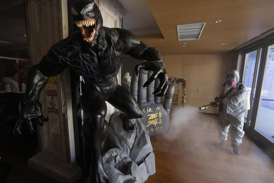 Volunteers with the Blue Sky Rescue team perform disinfecting of a cinema before it reopens for business in Beijing Friday, July 24, 2020. Theaters in China, the world's second largest movie market, this week reopened from the coronavirus shut down with theaters limited to 30% capacity. (AP Photo/Ng Han Guan)